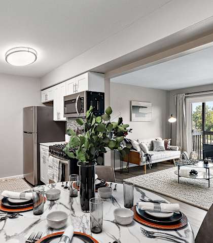 an open kitchen and living room with a dining table and chairs at Residences at Grand Blanc Apartments - Grand Blanc, MI, Grand Blanc Twp