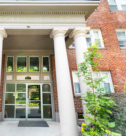 a picture of the front of a building with large white columns at Carolina Court, WA 98109
