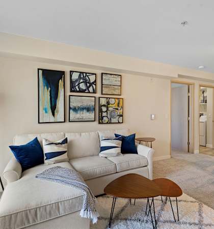 a living room with a white couch and blue pillows at Camelot Apartment Homes in Everett, WA