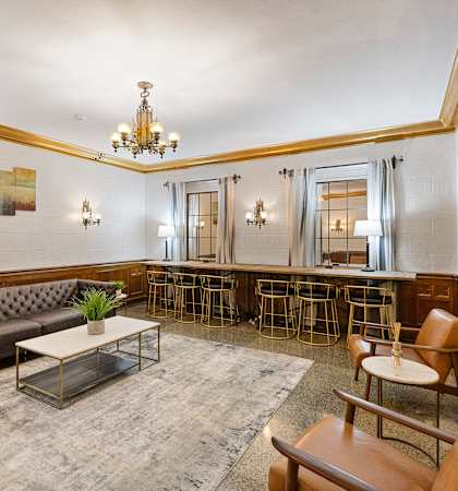 a lounge area with couches chairs a coffee table and a bar