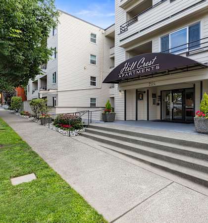 a large white building with a black awning at Hill Crest Apartment Homes, Washington, 98126
