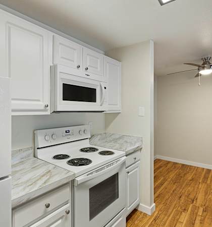 a kitchen with white cabinets and white appliances at Serra Vista Apartment Homes, Washington, 98087