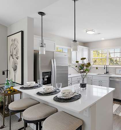 A modern kitchen with a breakfast table set for two.
