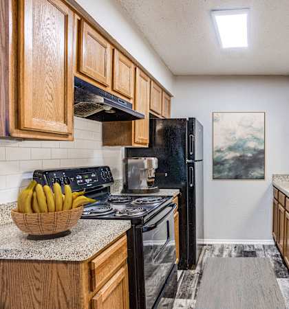 a kitchen with wood cabinets and black appliances