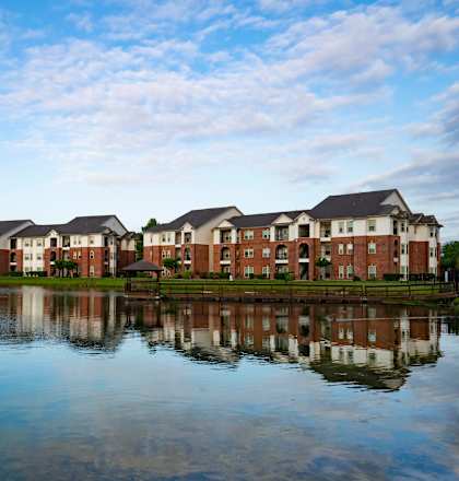 a view of a lake with apartments in the background