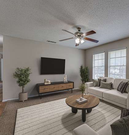 A living room with a couch, a coffee table, and a television.