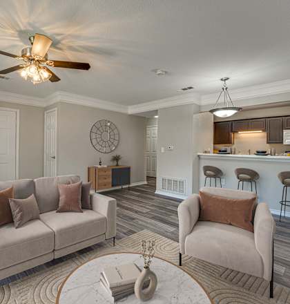 A living room with a couch, chairs, and a ceiling fan.