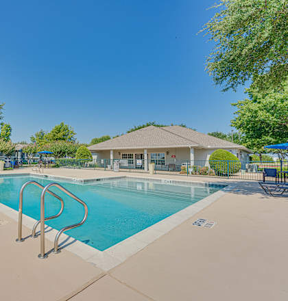 A large outdoor swimming pool with a diving board.