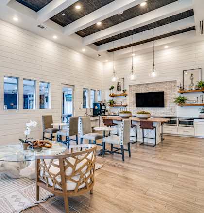 A modern kitchen and dining area with wooden floors and furniture.