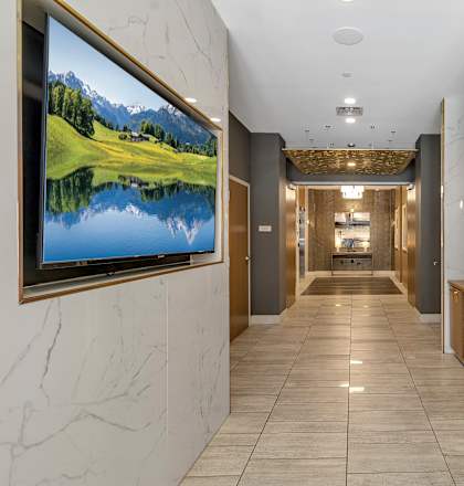 View of a hallway with mailboxes and a television on the wall at Nineteen North, Buffalo, New York