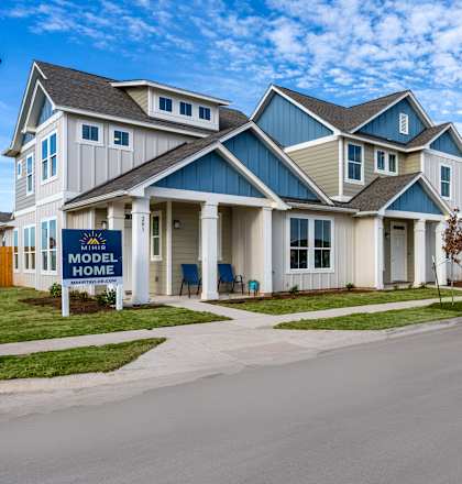 townhome exterior with green grass lawn at Mihir Taylor, Taylor