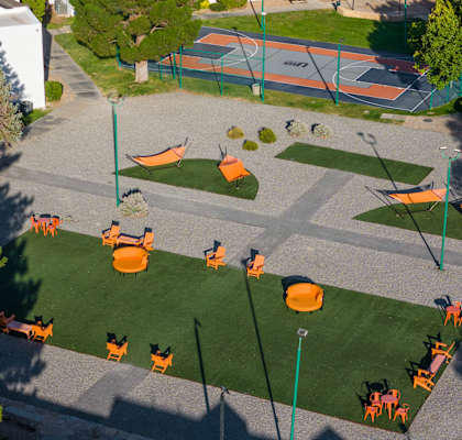an aerial view of a playground with orange chairs and grass