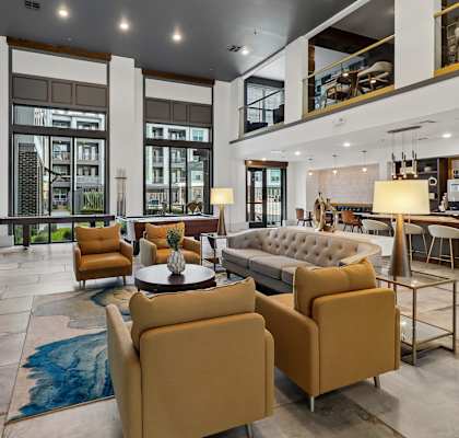 A modern living room with a large sofa, armchairs, and a coffee table.