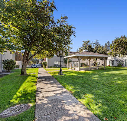 a gazebo sits in the middle of a grassy area