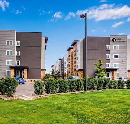 an exterior view of an apartment building with a parking lot at Parks Residential - Denver, Centennial
