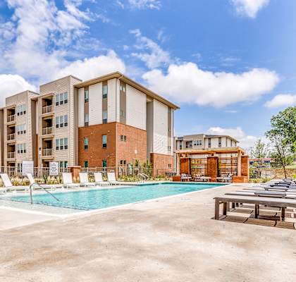 A large apartment complex with a pool in the foreground.