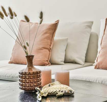 A table with a vase, candles, and a decorative item on it.