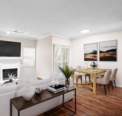 a living room with a fireplace and a dining room in the background
