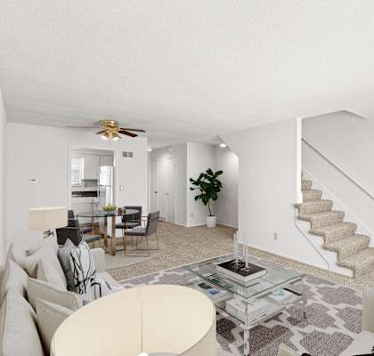 a living room with couches and a table and a staircase