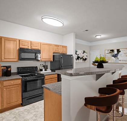 A kitchen with wooden cabinets and black appliances.