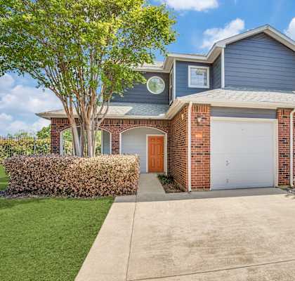 a blue and brick house with a white garage door