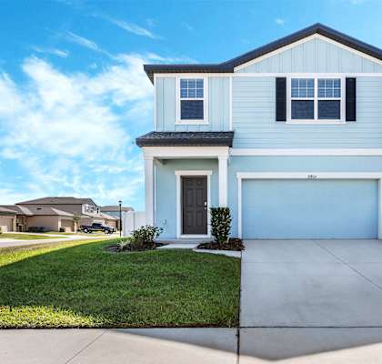 A two-story house with a garage and a driveway.