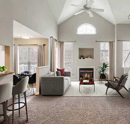 A modern living room with a fireplace and a dining area.