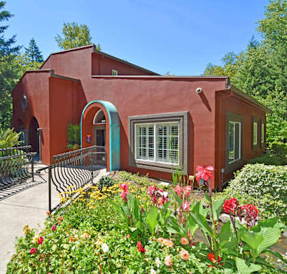 A red house with a garden in front.