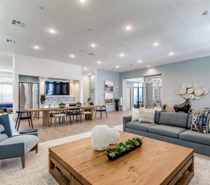 A modern living room with a grey sofa, a wooden coffee table, and a large window.