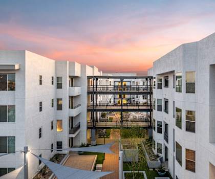 A view of the courtyard between two white buildings with three stacked bridges between the two buildings at Skywater at Tempe Town Lake Apartment Homes. 