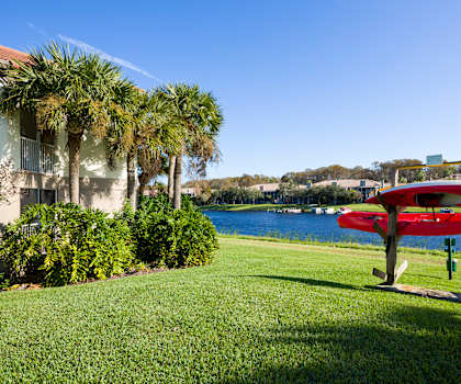 a red plane sits on a picnic table in front of a body of water