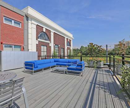 a large patio with a blue couch and a table and chairs