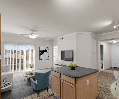 A well-lit kitchen and living room with modern furniture.