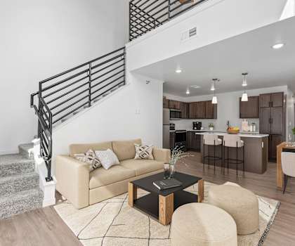 A living room with a staircase and a couch.