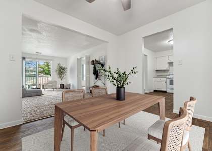 A dining room with a wooden table and chairs.