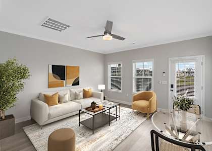 a living room with a couch and a coffee table and a ceiling fan