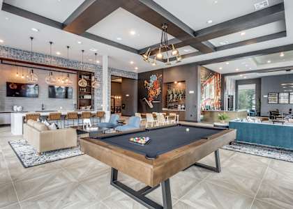 a living room with a pool table and a bar