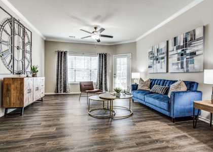 a living room with a blue couch and a ceiling fan at Village of Hawks Creek, Westworth Village, TX, 76114