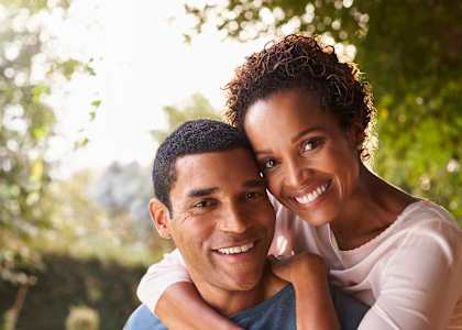 a man and a woman smiling and hugging each other