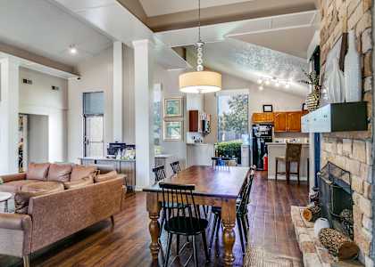 a living room with a fireplace and a dining table