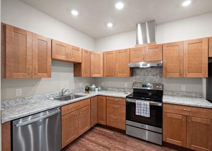 an empty kitchen with wooden cabinets and stainless steel appliances