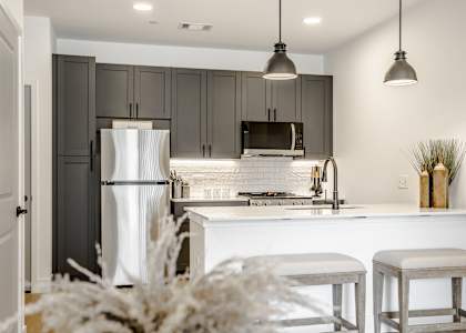 a white kitchen with a white counter top and a refrigerator at The James at Chatham Hills, Westfield, IN
