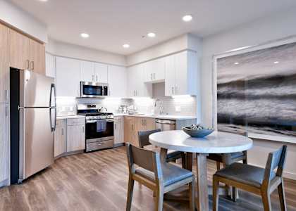 a kitchen with stainless steel appliances and a round table with chairs