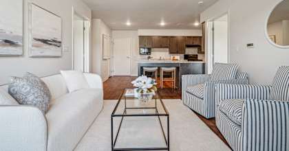 A living room with a white couch and a striped armchair.