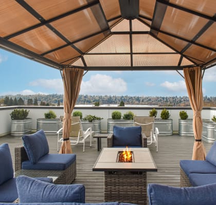 a roof terrace with blue couches and chairs and a fireplace  at The Loop at Green Lake, Seattle, Washington