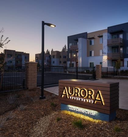 The Aurora Apartments sign at dusk