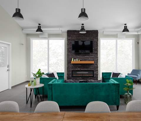 a living room with a green couch and a brick fireplace