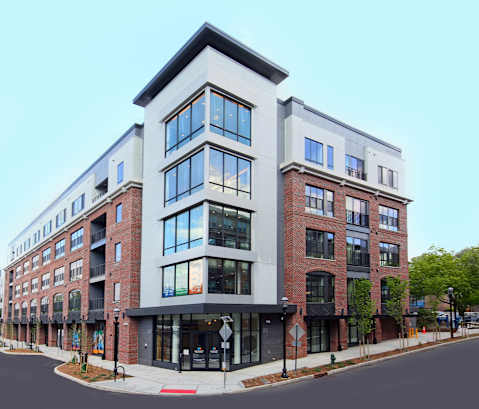 A modern multi-story building with a mix of brick and white exterior.