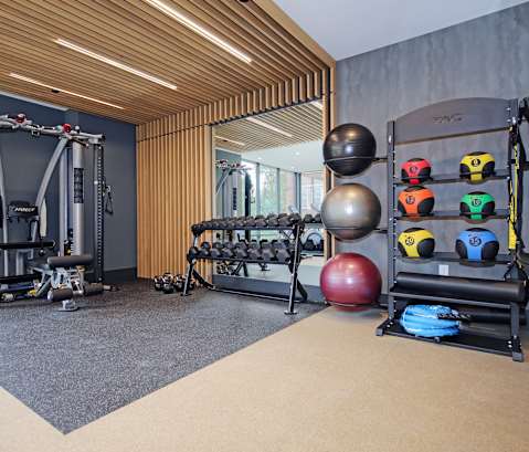 A gym with a variety of equipment including weights and a leg press machine.