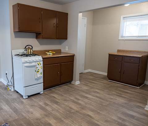 A kitchen with a white stove and brown cabinets.